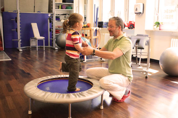 Physiotherapie Nils Hanke in einer Gleichgewichtsbehandlung an einem Kind.